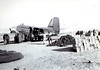 Pechner > Supplies being unloaded from USAF C-47, #349035,  on 5 December 1950 at Hagaru-ri air strip, Chosin Reservoir, N. Korea. Dead in sleeping bags (lower left) await evacuation. Photo by Sgt. W.R. Keating, USMC.
Bill Brennen